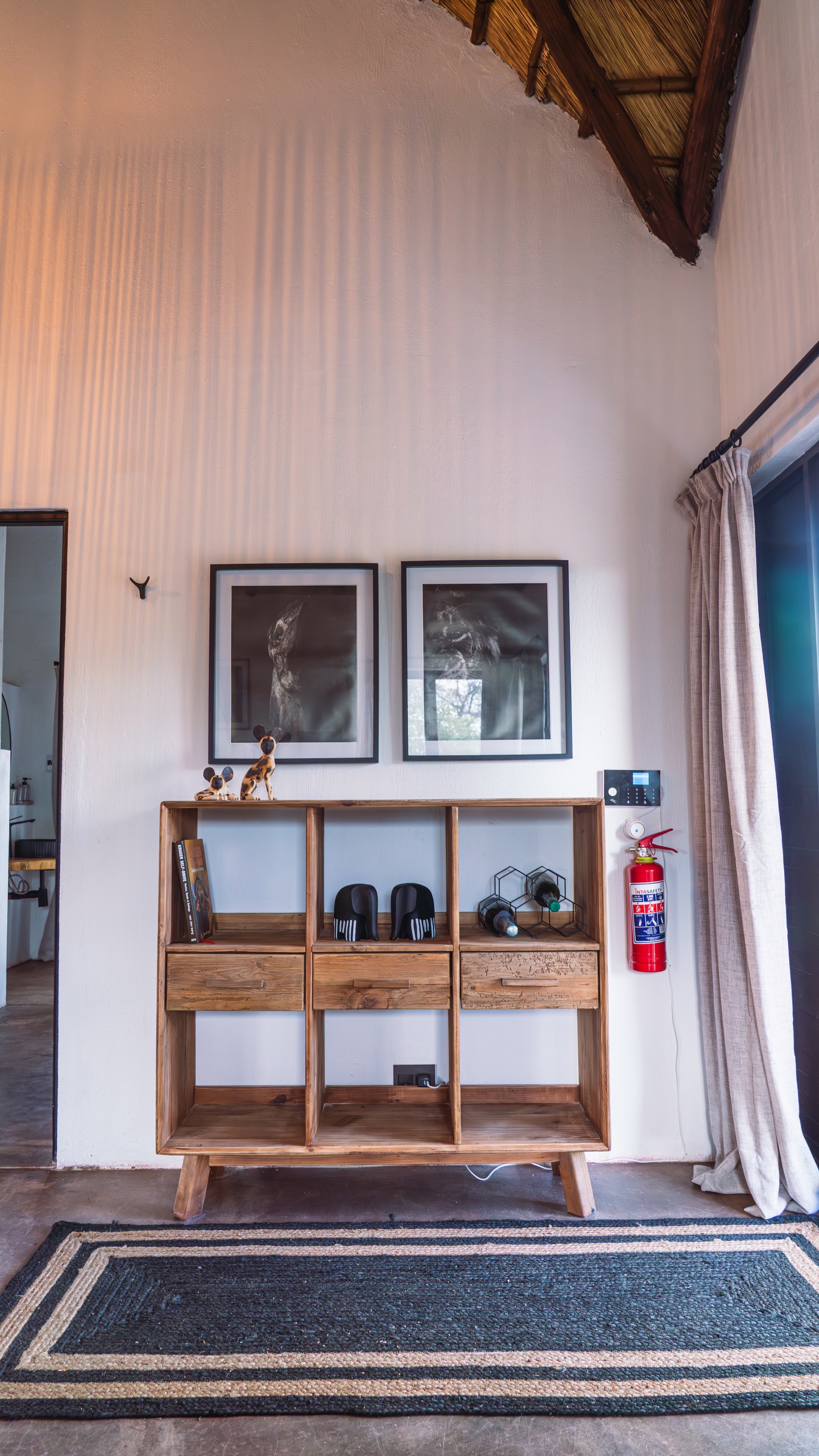 A reclaimed-wood console under framed wild dog prints