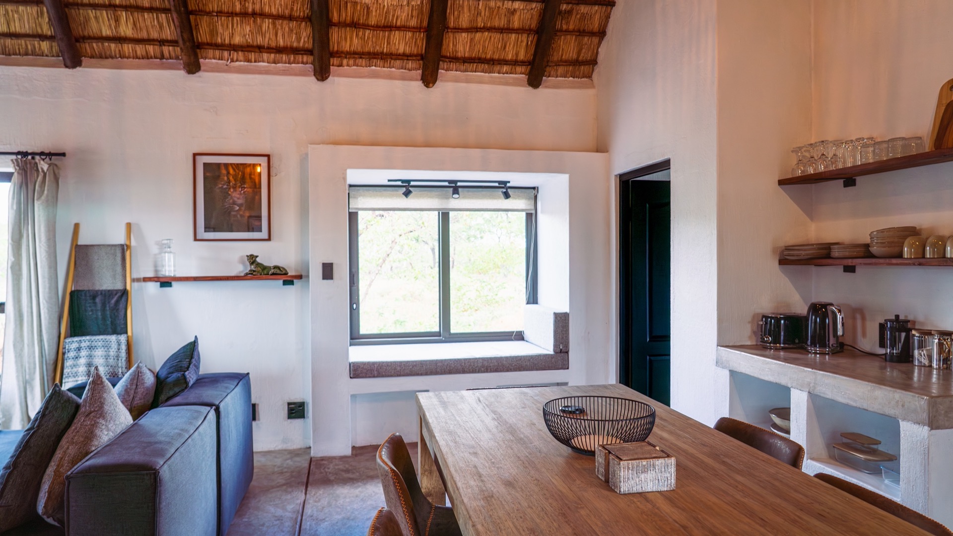 Open-plan lounge and dining under the soaring thatch roof