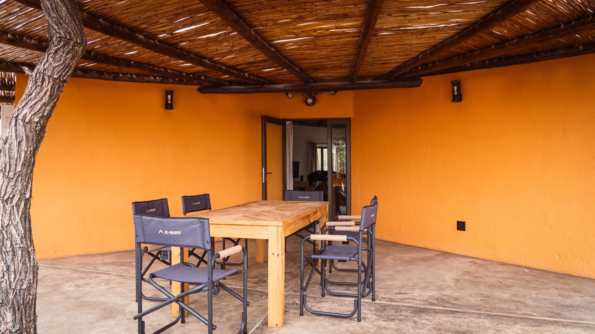 The wraparound patio with its long table and ochre walls